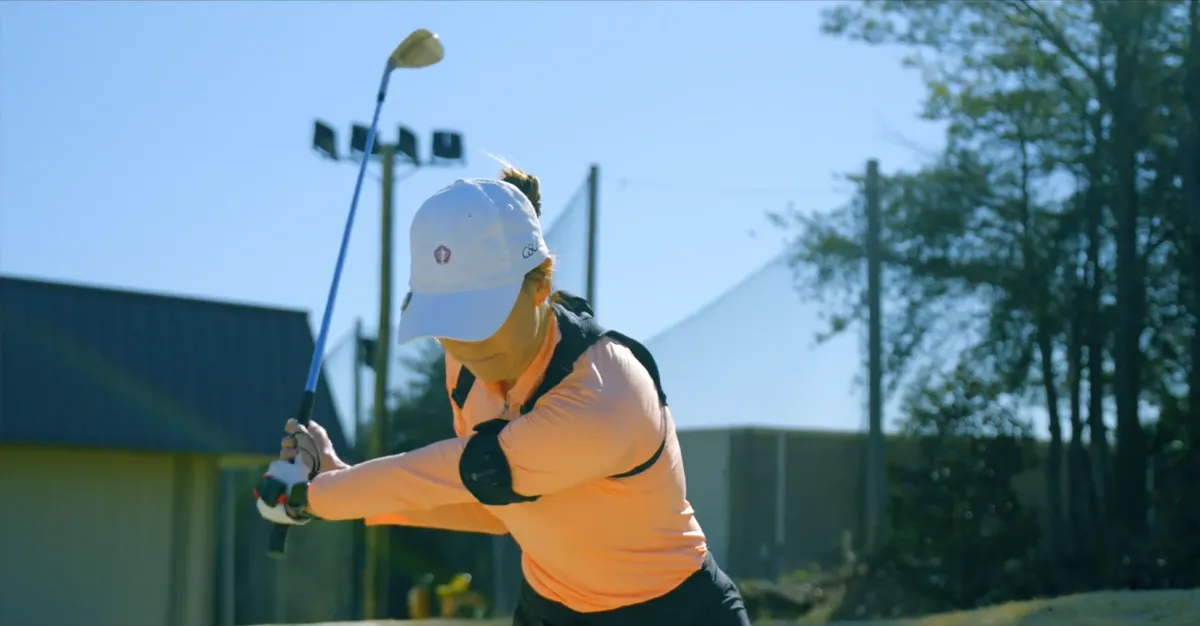 Golfer at the top of the follow-through on the range