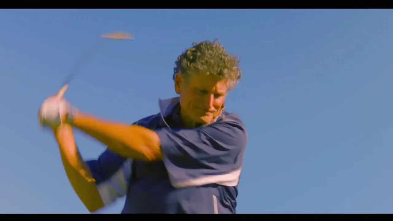 Golfer at the moment of impact under a blue sky